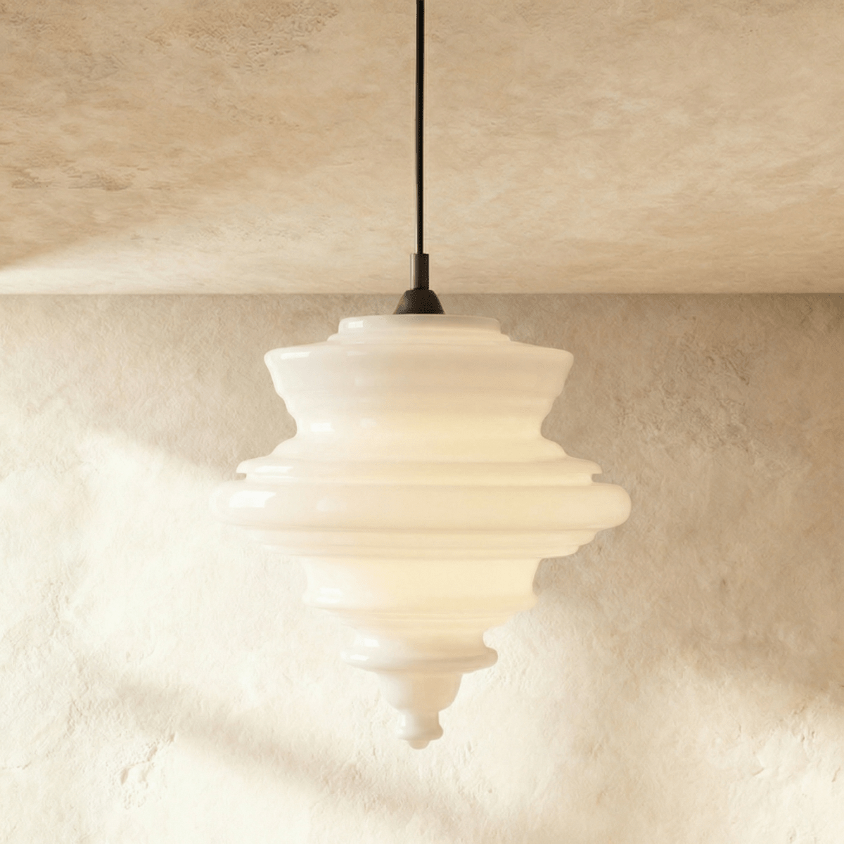 Clérachic's pendant light in milk white glass, a tiered ribbed shade hanging from a dark cord overhead.