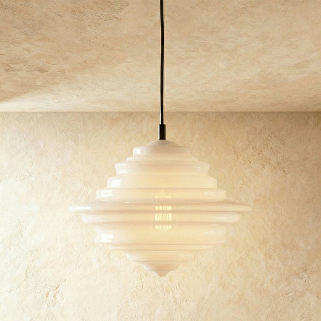 Clérachic's pendant light in milk white glass, a compact bulbous shade glowing softly on a dark cord.