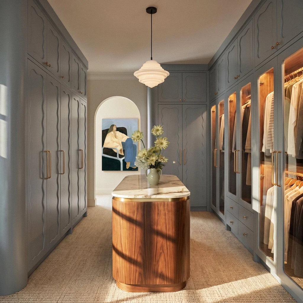 Clérachic's pendant light in milk white glass, hanging above a marble-topped island in a walk-in closet.