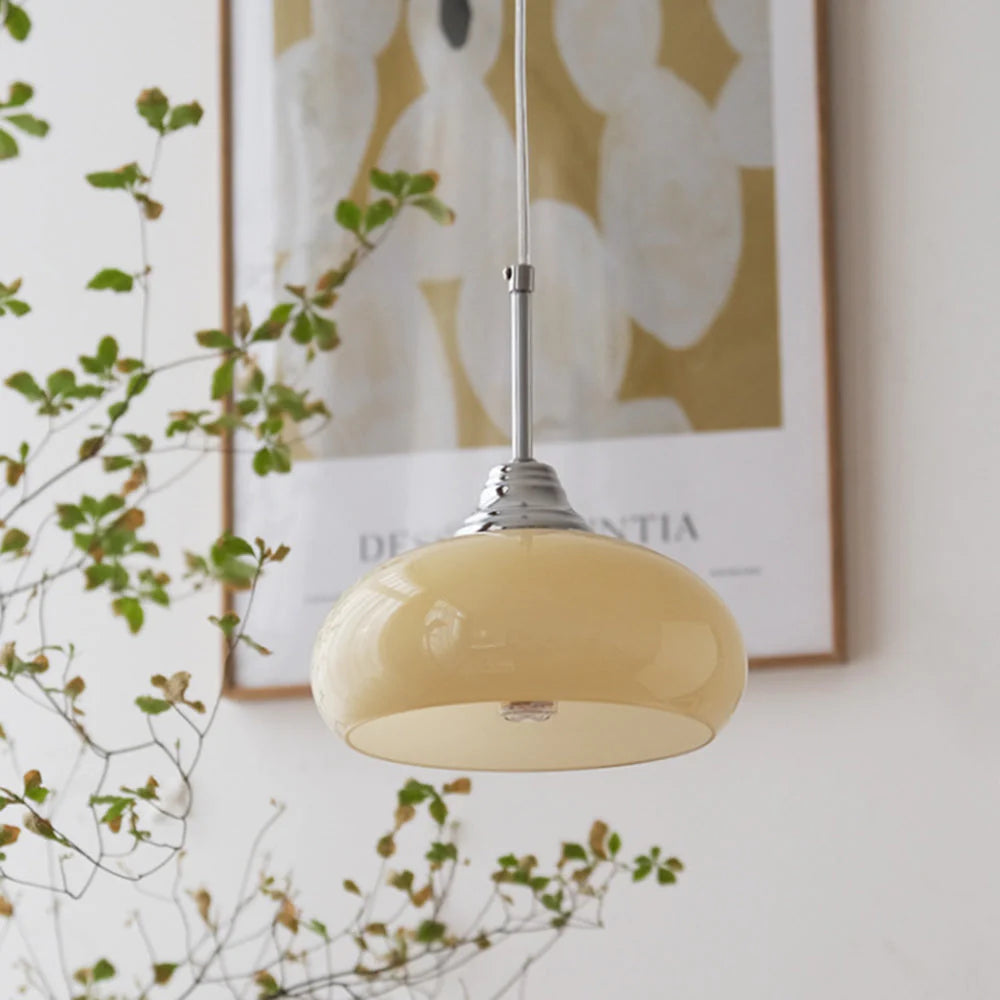 Clérachic pendant light lit, the glow through the shade in a quiet room.