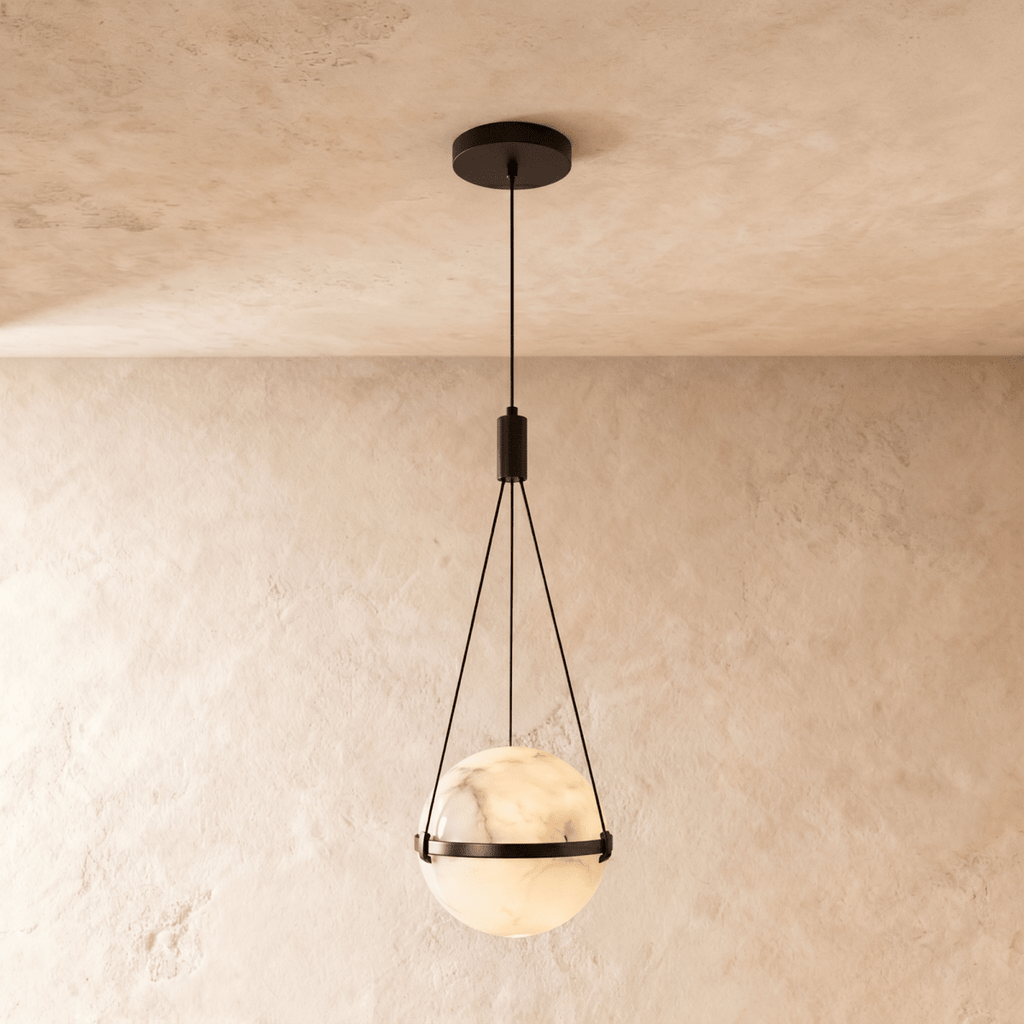 Clérachic marbled alabaster globe pendant with a slim dark metal band and three suspension cords, glowing softly on limewash.