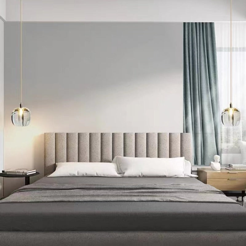 A pair of clear Clérachic mini bubble glass pendant lights on slim cords flanking a bed in a grey and teal bedroom