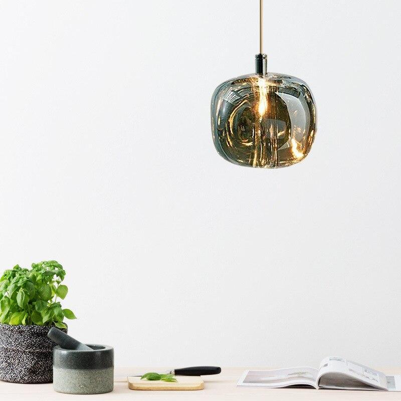 Smoky gray Clérachic mini bubble glass pendant light lit over a kitchen worktop set with basil, a mortar and a chopping board