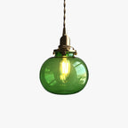 Clérachic Mini Glass Pendant Light in green shown on white, a filament bulb glowing inside the smooth oval shade.