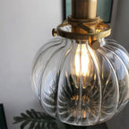 Close-up of the fluted clear shade on the Clérachic Mini Glass Pendant Light, the filament breaking into a starburst below.