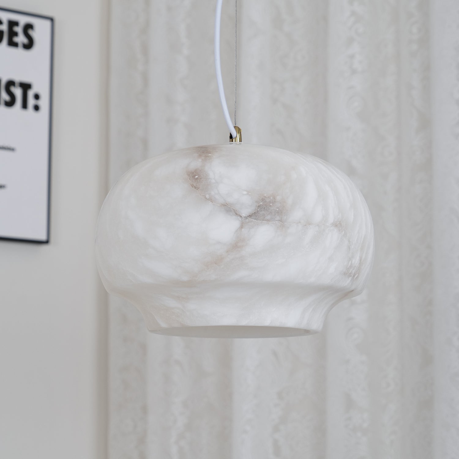 Clérachic alabaster pendant unlit beside a lace curtain, natural stone reading soft cream.
