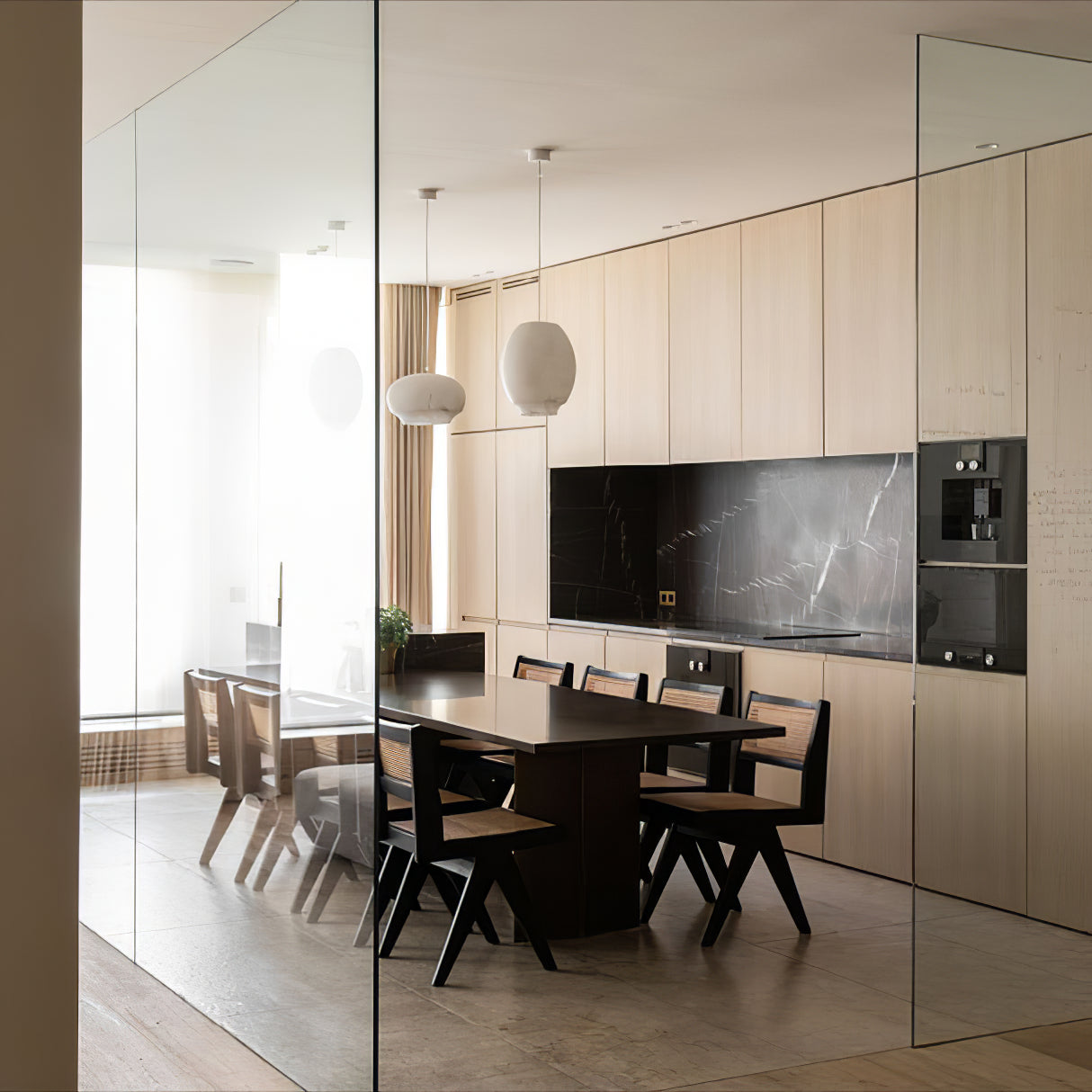 Clérachic alabaster pendants seen through a glass partition above a long timber dining table.