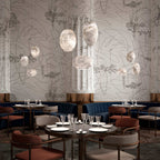 Clérachic alabaster pendants clustered above restaurant tables against patterned wallpaper.