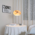 Clérachic alabaster pendant lit above a round table beside a framed print and lace curtain.