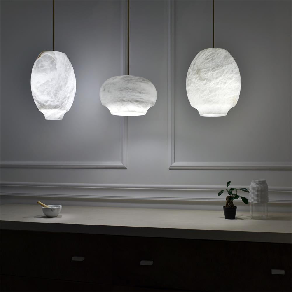 Three Clérachic alabaster pendants lit against a grey panelled wall above a low ledge.