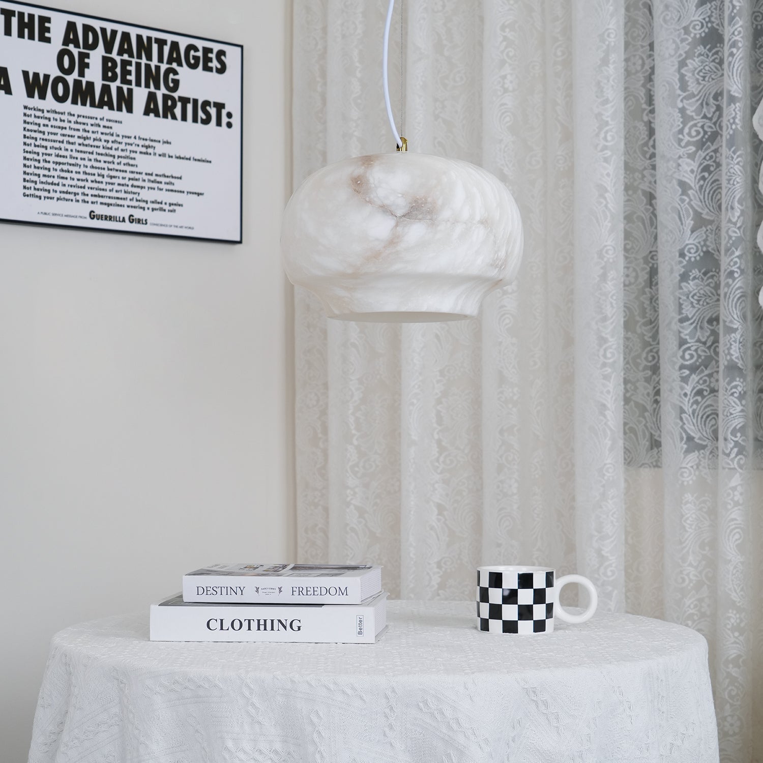Closer view of the Clérachic alabaster pendant lit above the same round cloth-covered table.