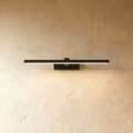 Clérachic slim black linear wall light, 39.5 cm, glowing warm along its diffuser on a textured limewash wall.