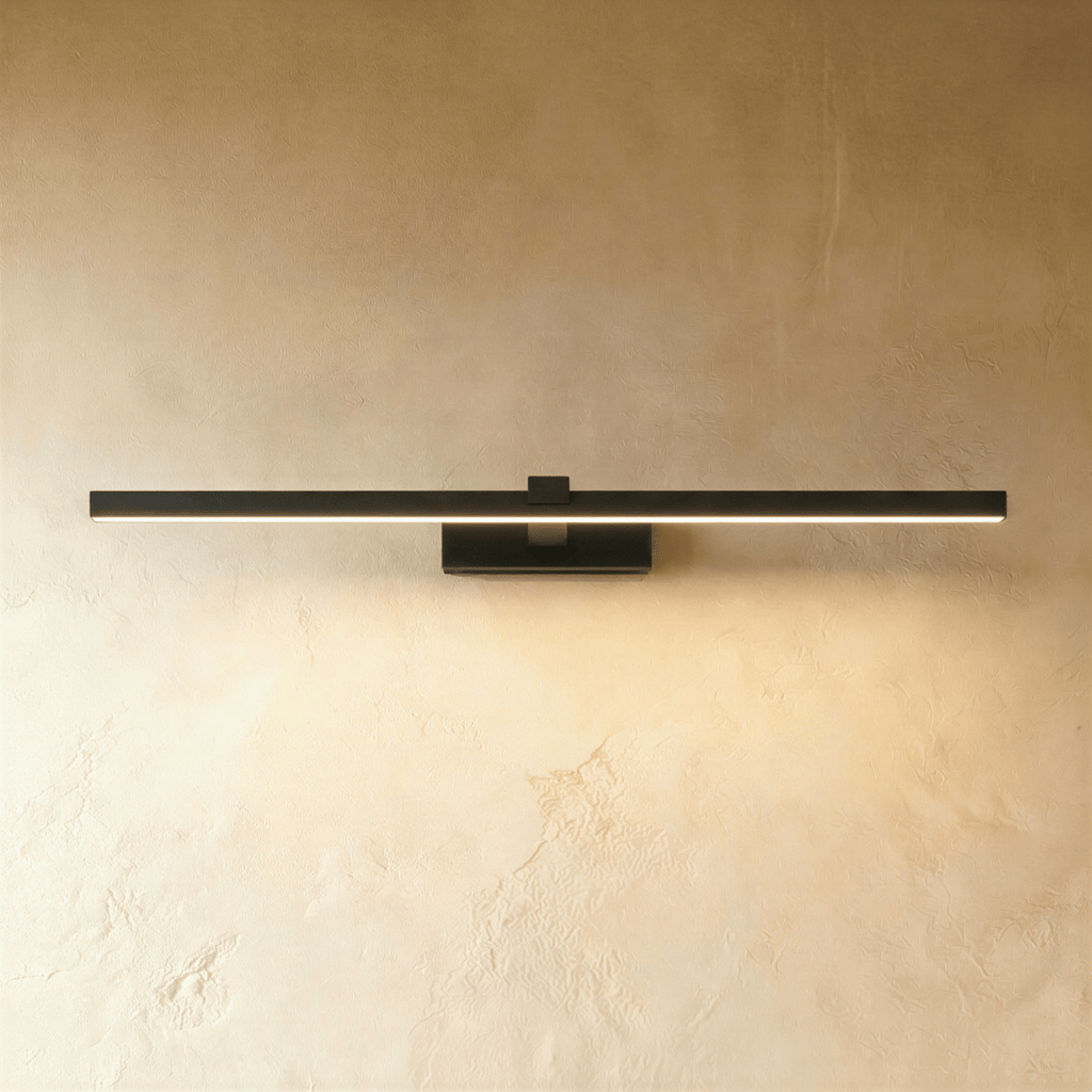 Clérachic slim black linear wall light in its longest length, lit along the diffuser on a textured limewash wall.