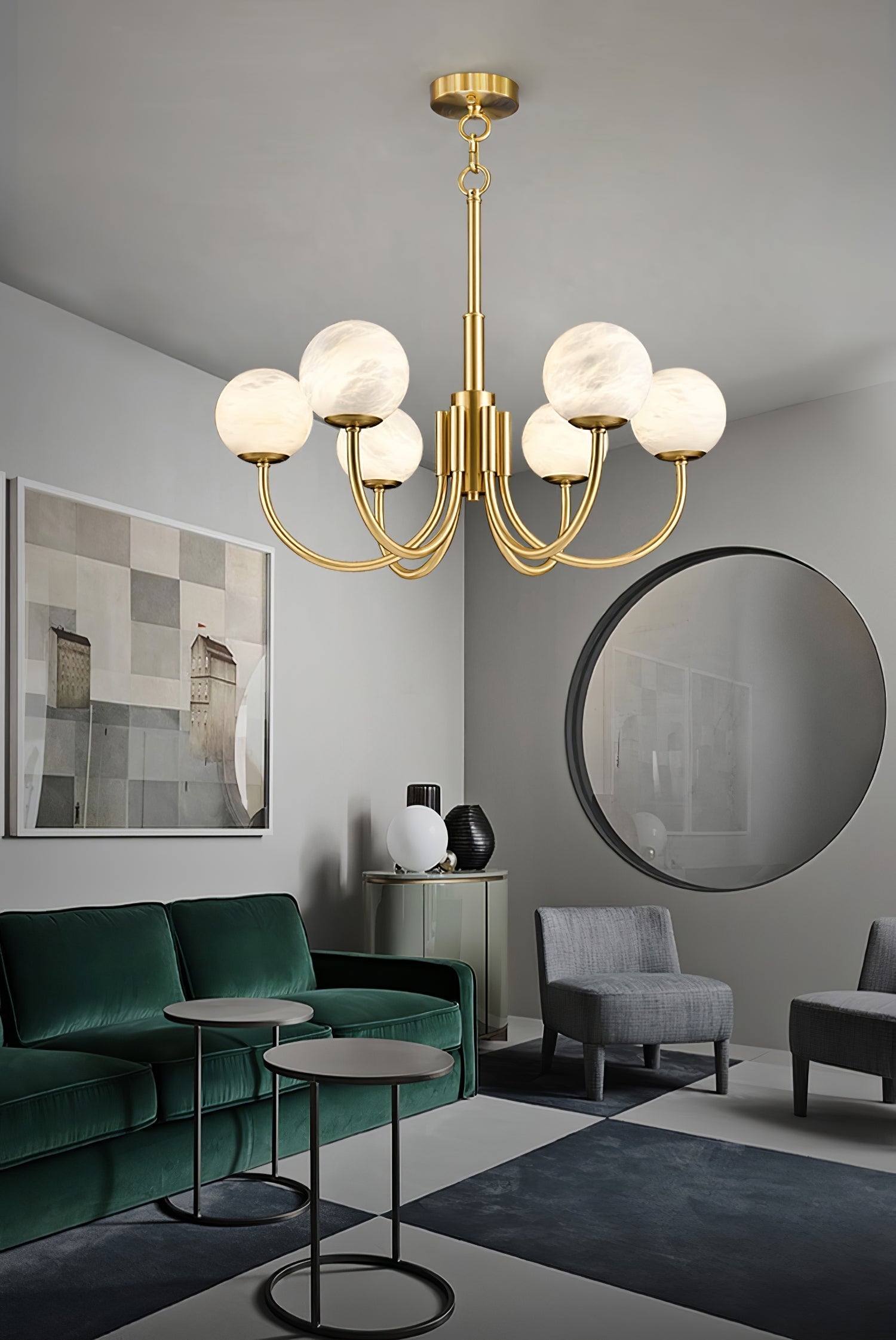 Clérachic globe chandelier lit in a grey living room above a green velvet sofa and round mirror.