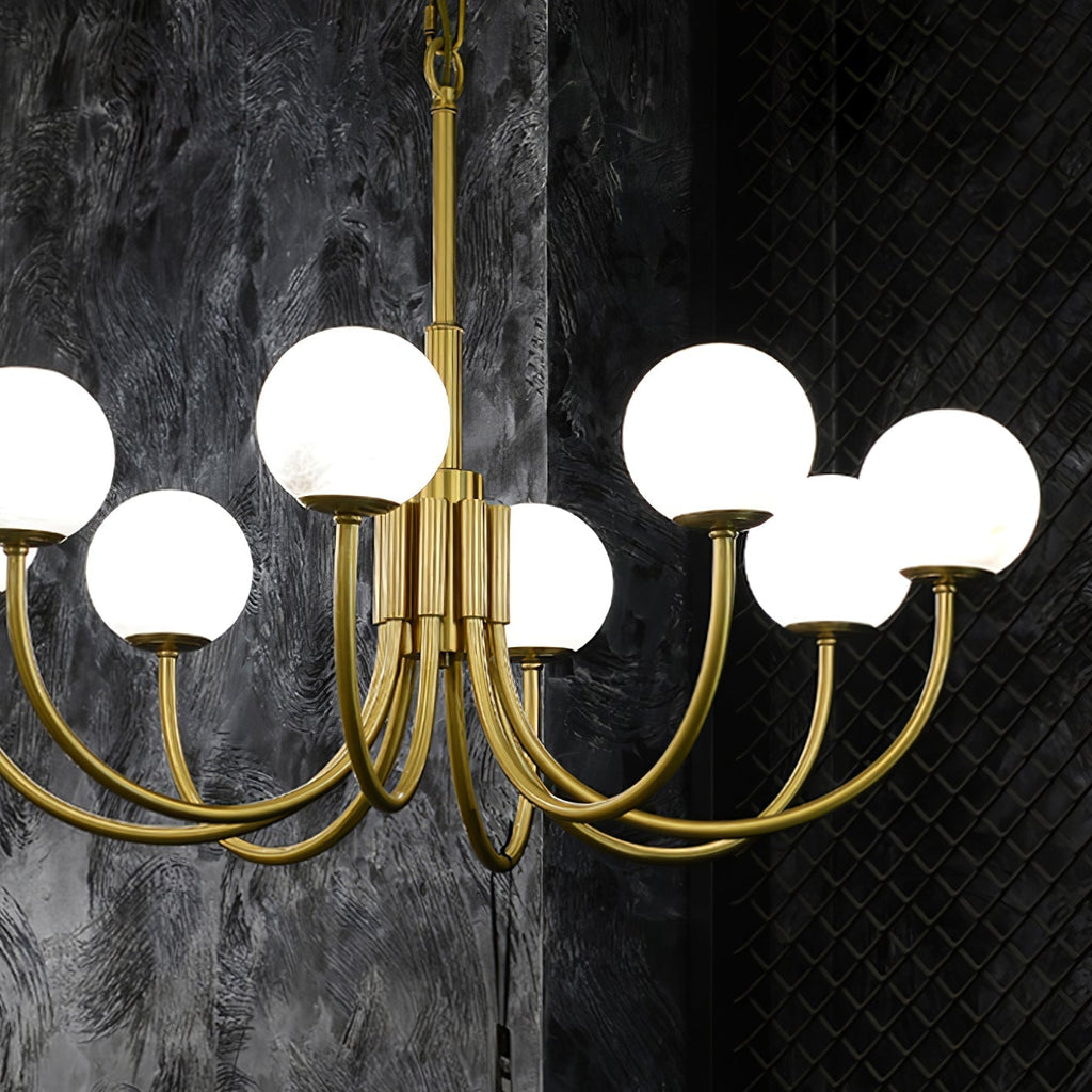 The Clérachic globe chandelier lit against a dark textured wall, stone shades glowing softly.