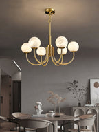 Clérachic globe chandelier above a round dining table in a grey room with a plaster bust.