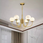 Clérachic globe chandelier fitted to a white ceiling with timber trim and floor-length curtains.