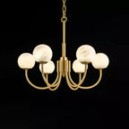 The Clérachic globe chandelier on black, eight alabaster spheres lifted on curved brass arms.
