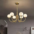 Clérachic globe chandelier lit in a pale arched room beside a framed artwork and dried stems.