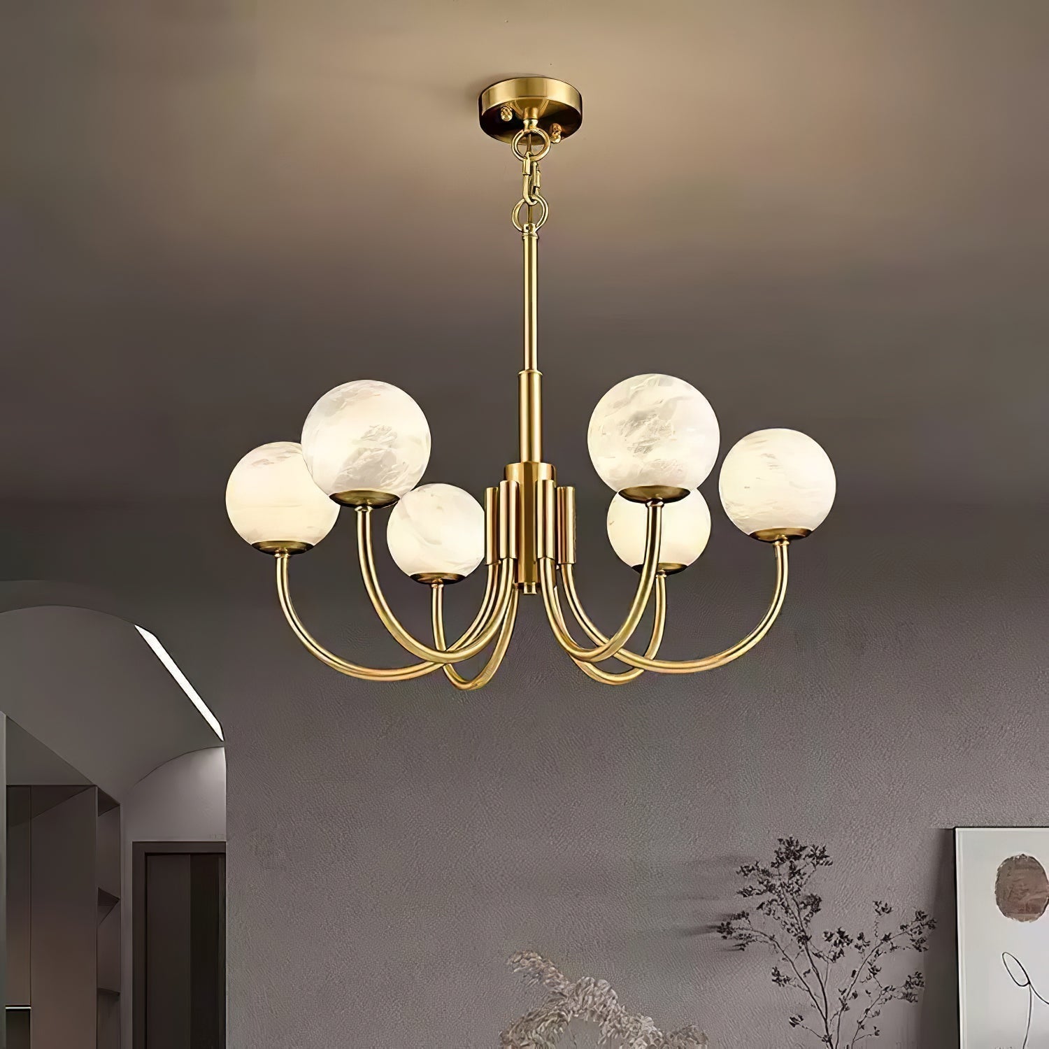 Clérachic globe chandelier lit in a pale arched room beside a framed artwork and dried stems.