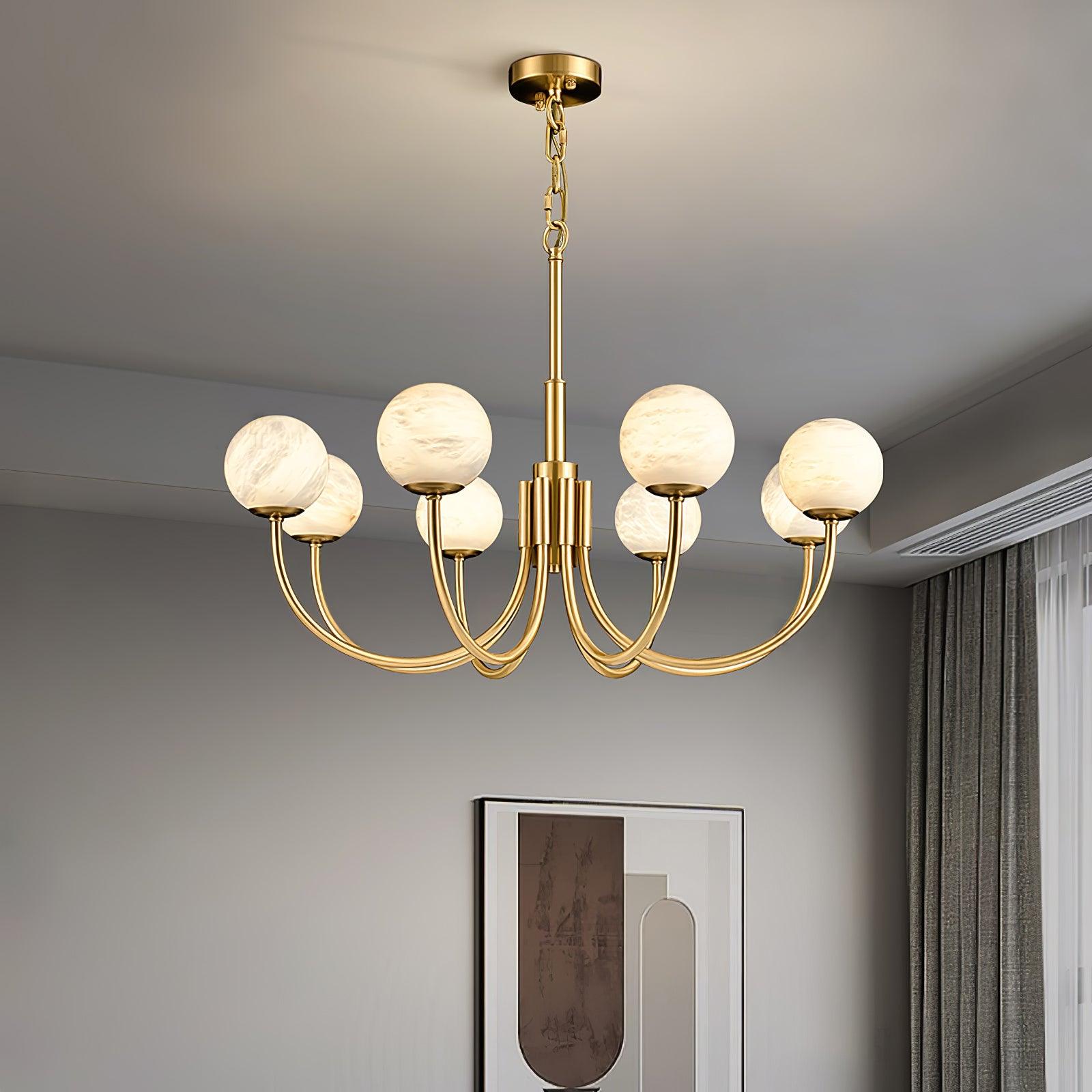 Clérachic globe chandelier lit below a white ceiling beside framed art and sheer curtains.