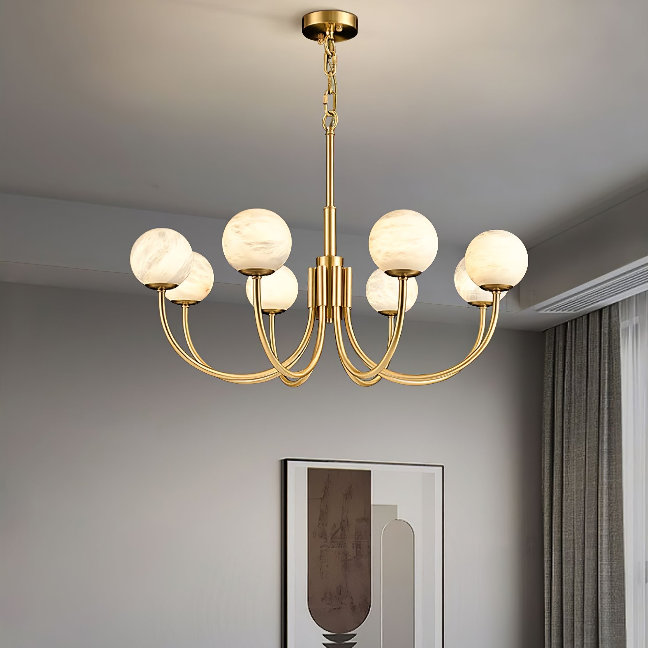 Clérachic globe chandelier lit in a pale room with drawn curtains and a framed print behind.