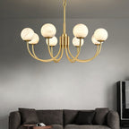 The Clérachic globe chandelier lit on grey above a dark sofa and low timber table.