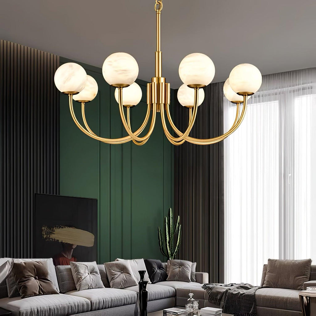Clérachic globe chandelier hung against deep green panelling above a pale sectional sofa.
