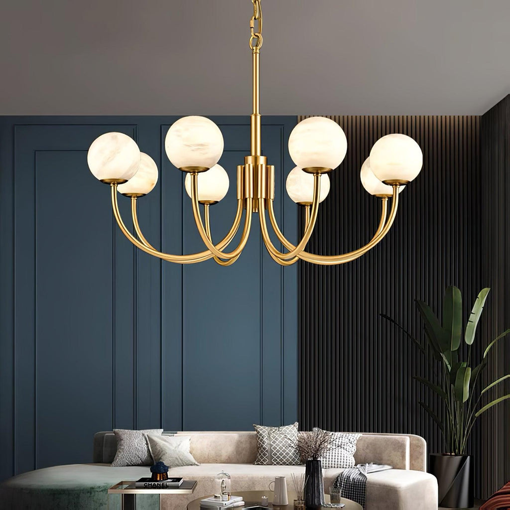 Clérachic globe chandelier lit against blue panelling, warm alabaster globes over a linen sofa.