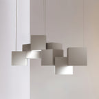 Close view of a white Clérachic cube chandelier against a pale wall, the cubes stacked at offset angles with light below.