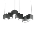 A Clérachic black cube chandelier on a plain white backdrop, the cubes at varied tilts with a lit opening on each underside.