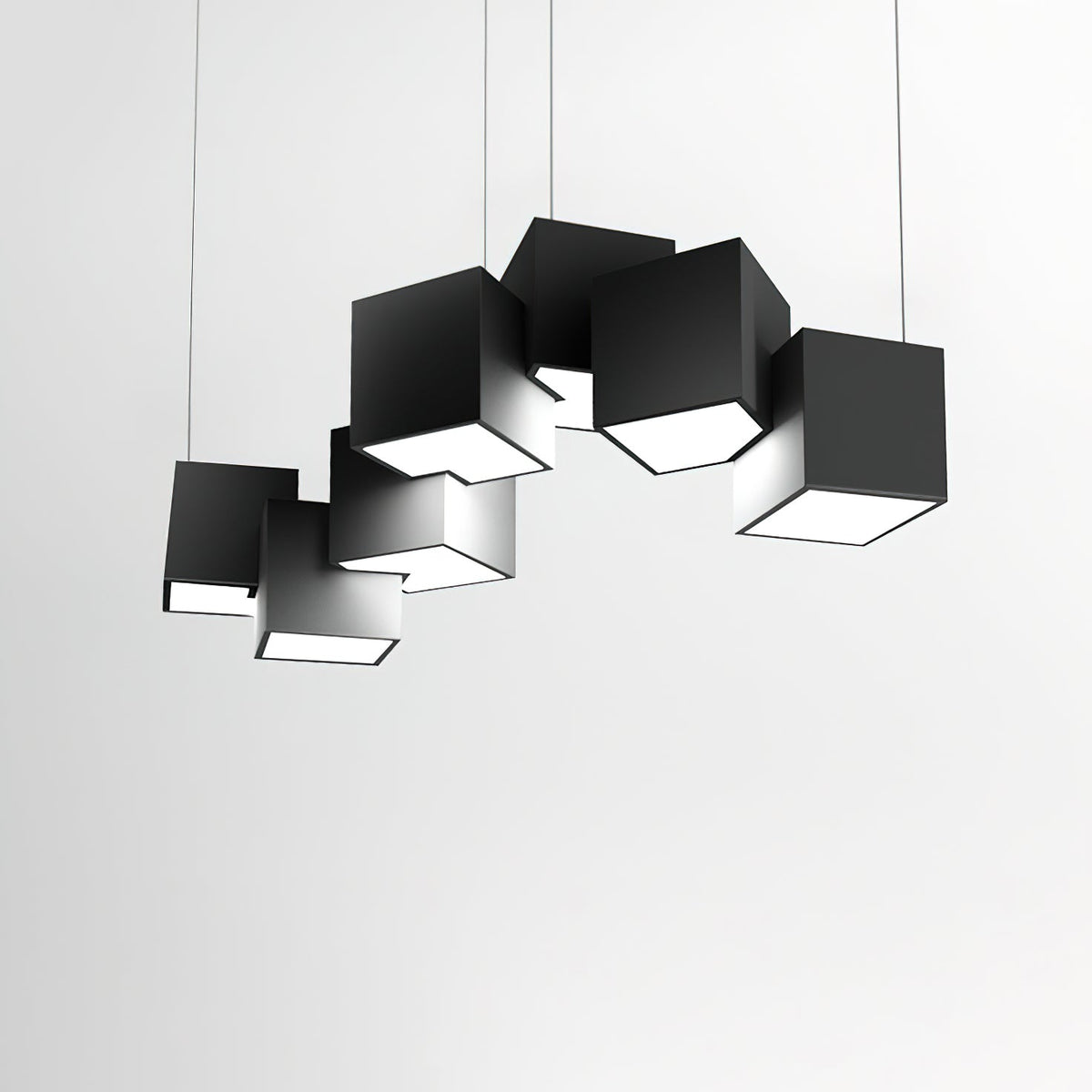 A Clérachic black cube chandelier against a pale grey wall, its tilted cubes casting soft shadows on one another.