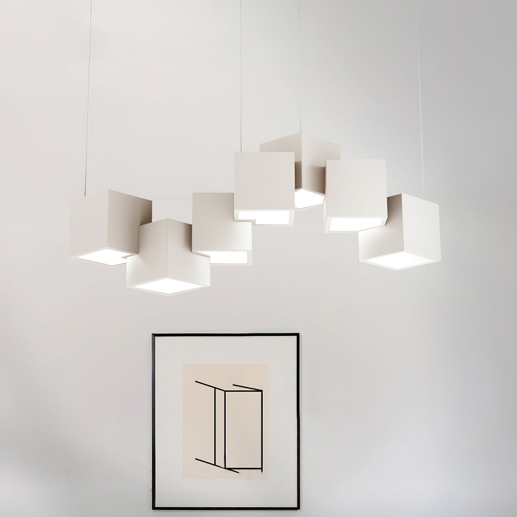 A Clérachic chandelier of white cubes in a row above a black-framed abstract print on a pale wall.