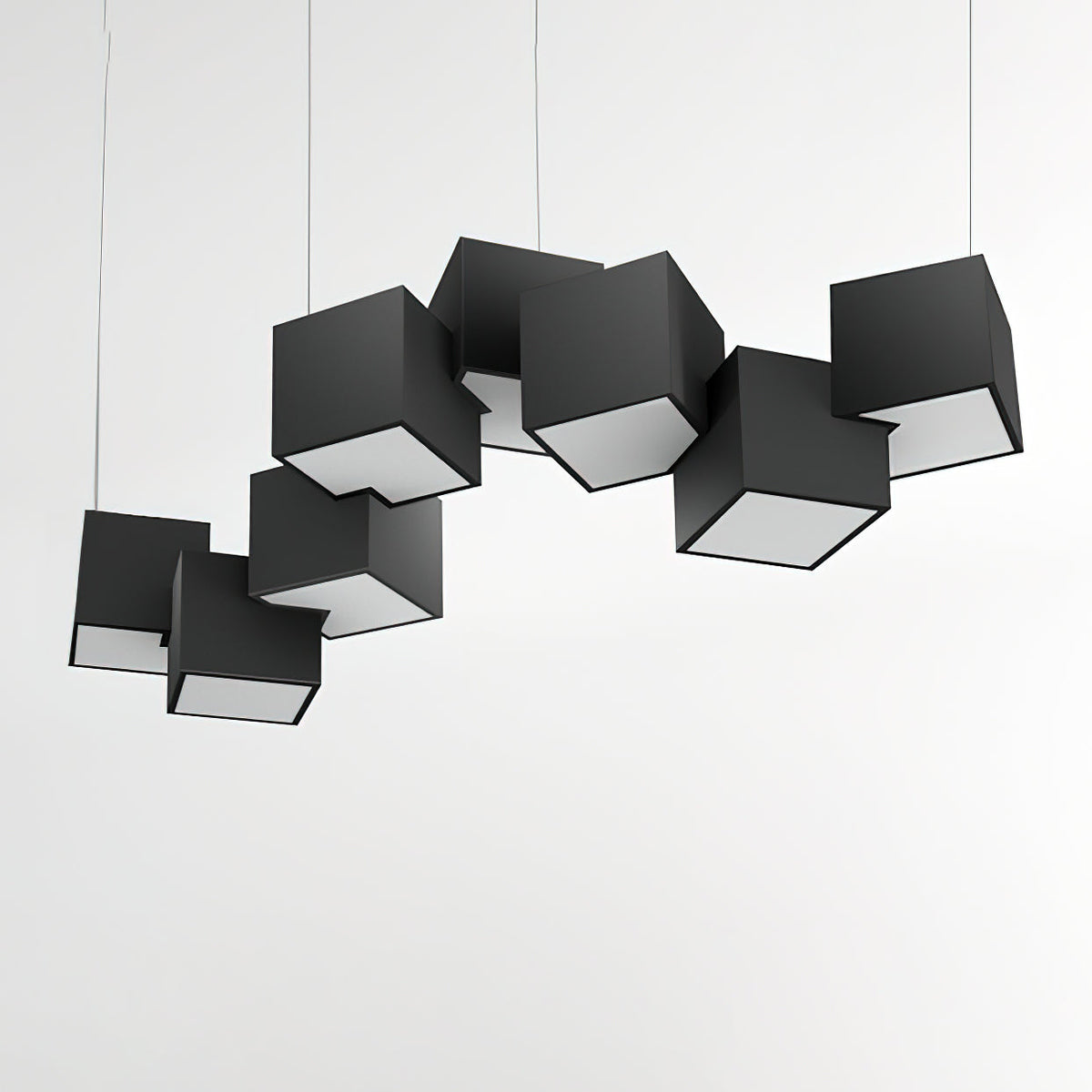 A Clérachic chandelier of black cubes over a pale wall, the tilted cubes showing their white lit undersides.