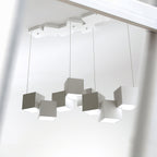 A Clérachic white and grey cube chandelier seen from below, with its cubes tilted and a canopy of cubes above.