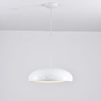 Small white Clérachic dome pendant on a long cable, with a white ceiling canopy and a soft glow at its base.