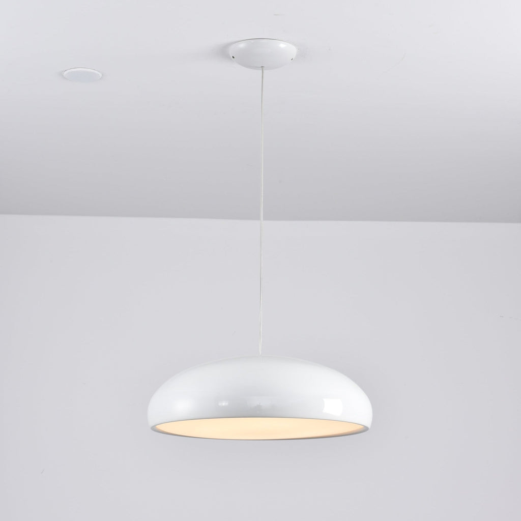 Glossy white Clérachic dome pendant lit from below, with a bright diffuser and a rounded white canopy above.