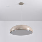 Warm grey Clérachic dome pendant tilted to show its flat grey diffuser disc, hung beside a ceiling spotlight.