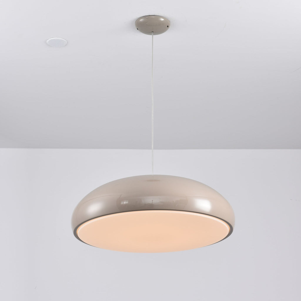 Warm grey Clérachic dome pendant lit from below, the diffuser glowing a soft peach inside its rim.