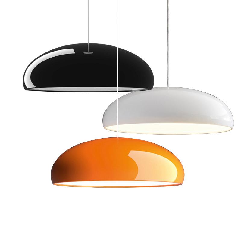 Black, white and orange Clérachic-style domes hung at staggered heights on a white backdrop, showing three finishes side by side.