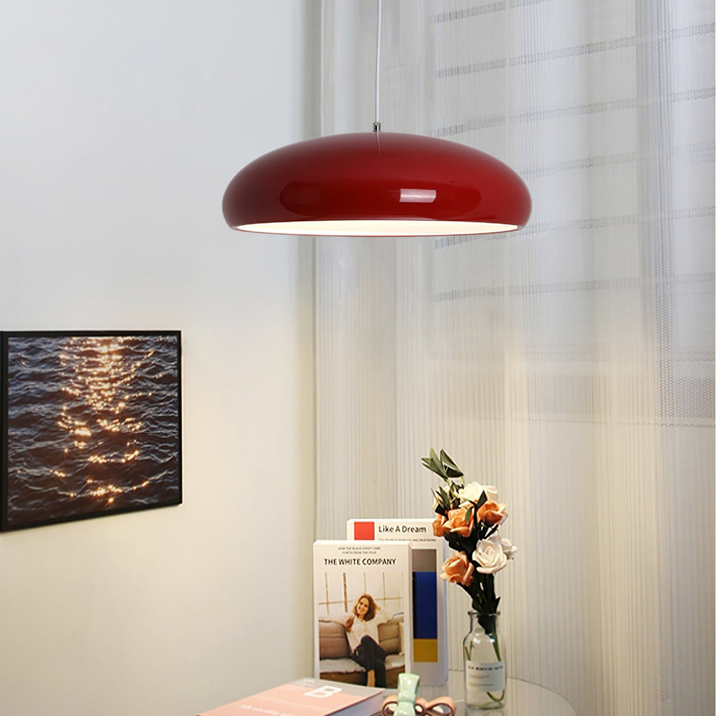 Dark-red Clérachic dome pendant beside sheer curtains, with a framed photograph of rippling water and a bunch of flowers below.
