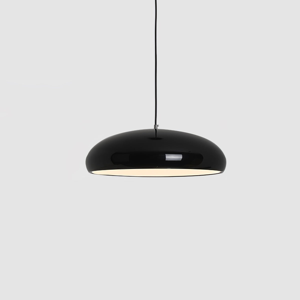 Black Clérachic dome pendant on a light grey backdrop, its white inner rim glowing under a thin black cable.