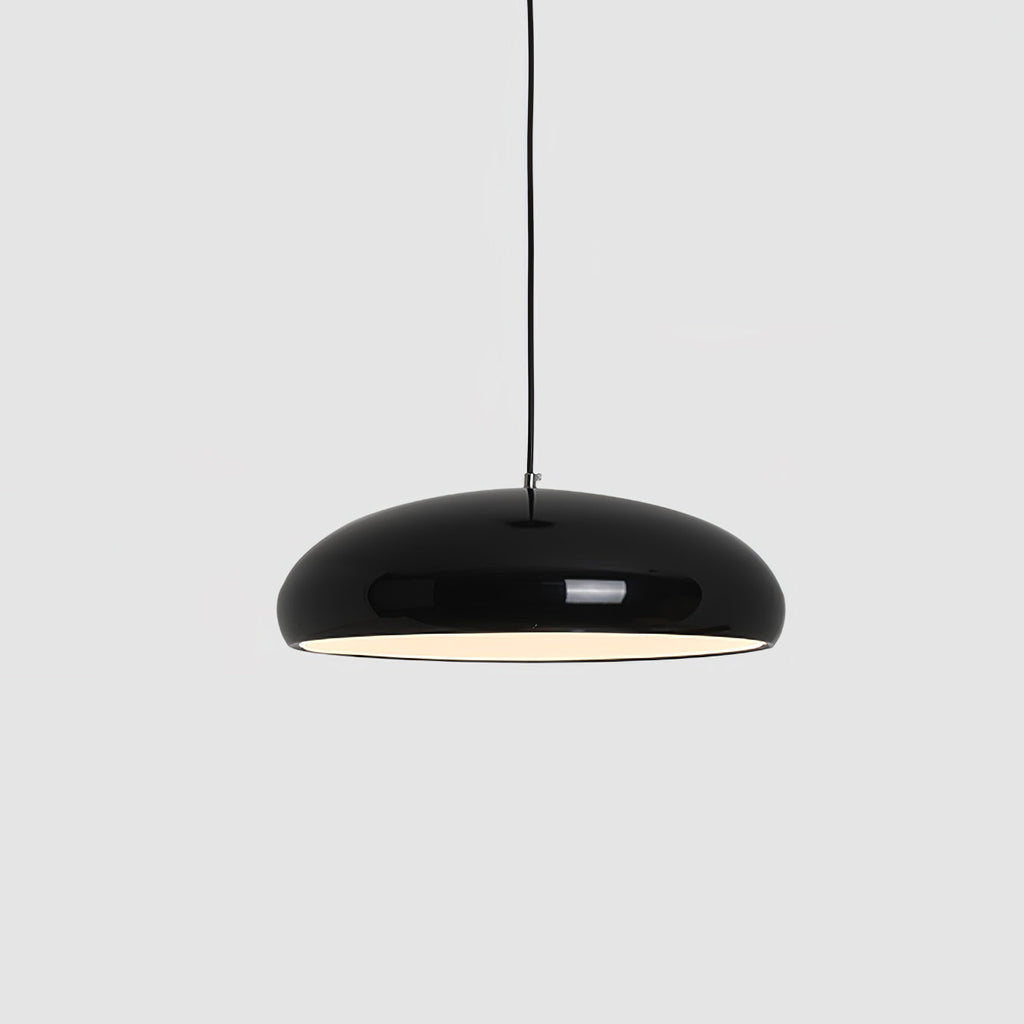 Close view of a black Clérachic dome pendant on grey, its glossy shell and warm white interior light both clear.
