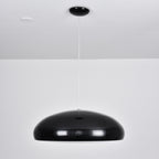 Black Clérachic dome pendant on a long white cable below a black canopy, with its shell reflecting the room.