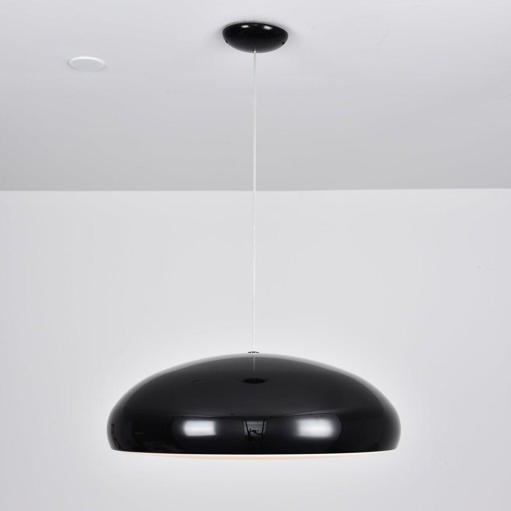 Wide, glossy black Clérachic dome pendant hung low from a black round canopy against a white wall.