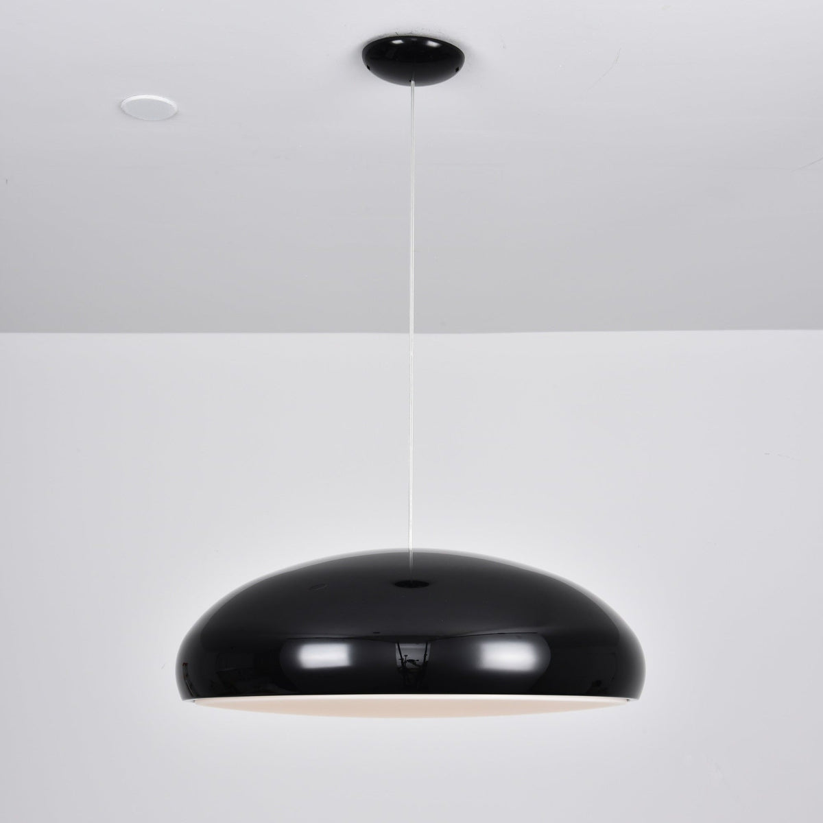 Black Clérachic dome pendant with a faint warm glow at its lower edge, hanging from a black ceiling canopy.