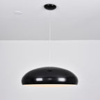 Black Clérachic dome pendant, side view, with a soft warm glow just visible under the shell and a spotlight overhead.