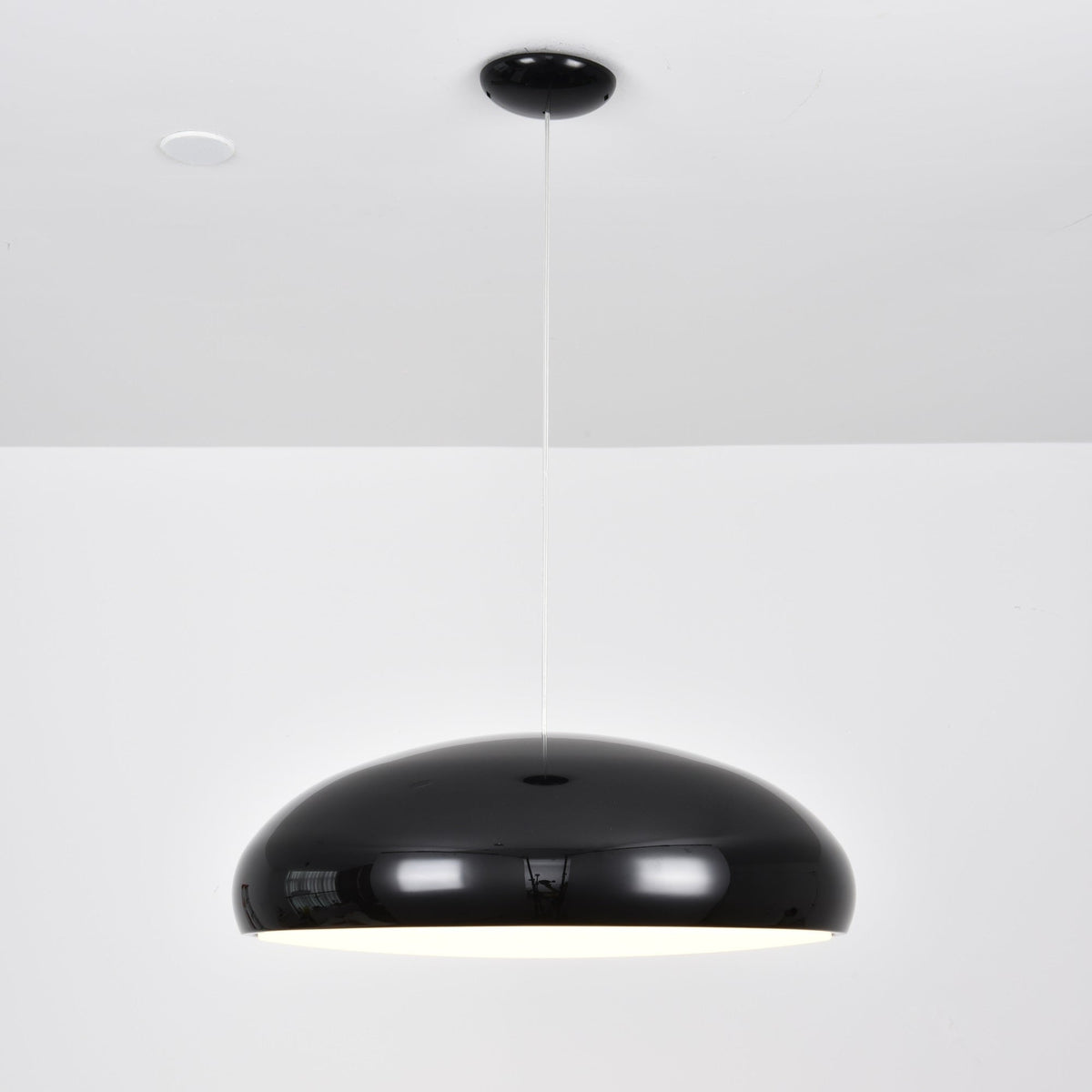 A black Clérachic dome pendant seen straight on, its shell glossy and its underside barely lit.