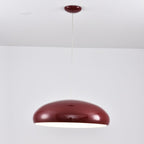 Dark-red Clérachic dome pendant with a bright white glow just showing at its lower edge, hung from a round canopy.