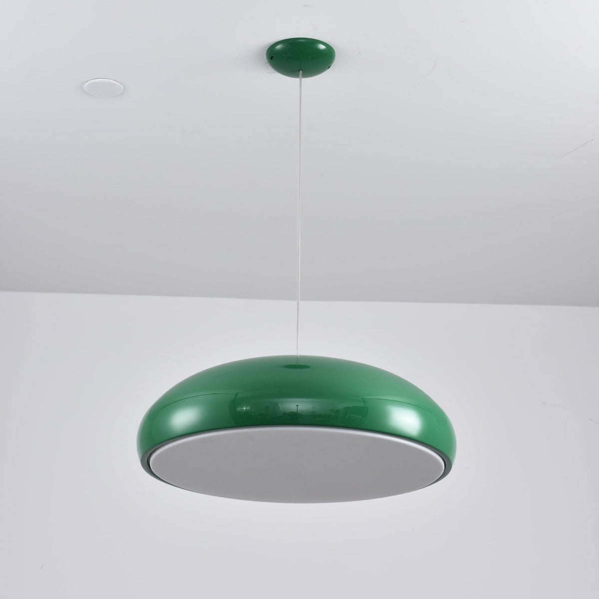 Green Clérachic dome pendant viewed from below, with an unlit grey diffuser disc inside its rim.